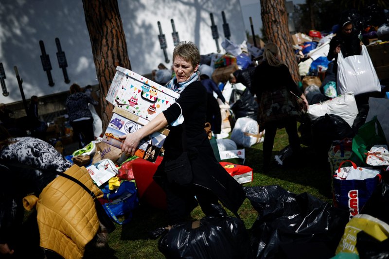 Una mujer lleva productos humanitarios para ser cargados en camiones como transporte de primera ayuda a Ucrania, tras la invasión rusa de Ucrania, en la Basílica de Santa Sofía, un centro religioso y cultural para expatriados ucranianos en Roma, el 3 de marzo de 2022. (Foto Guglielmo Mangiapane/Reuters vía CNS).