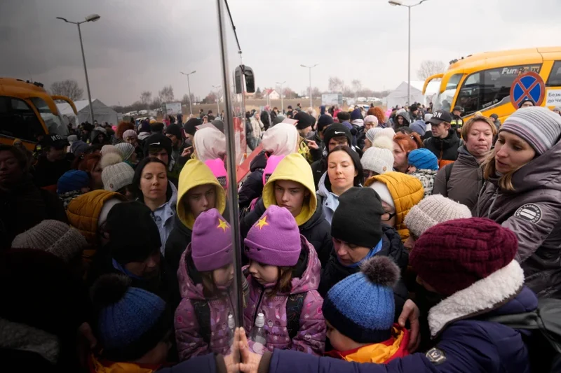 Personas que huyen de Ucrania hacen cola para subir a un autobús en el paso fronterizo de Medyka, Polonia, el viernes 4 de marzo de 2022. Más de un millón de personas han huido de Ucrania tras la invasión rusa en el éxodo de refugiados más rápido de este siglo, según informó el jueves Naciones Unidas. (Foto Markus Schreiber/AP)