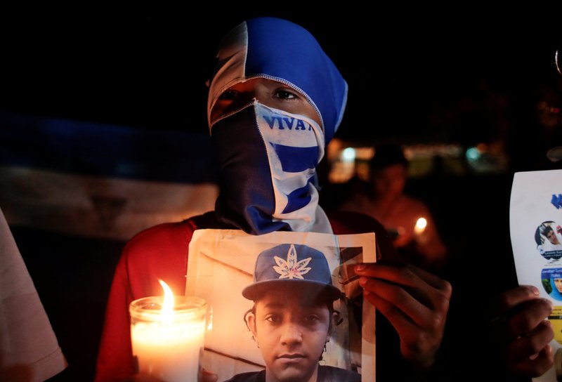 Un manifestante enmascarado participa en una vigilia con velas por los presos políticos y las víctimas de las protestas contra el gobierno del presidente nicaragüense Daniel Ortega en la Catedral Metropolitana de Managua el 3 de octubre de 2019. (Foto CNS/Oswaldo Rivas, Reuters)