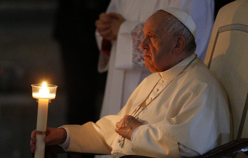 El Papa Francisco sostiene una vela mientras asiste a la Vigilia Pascual celebrada por el Cardenal Giovanni Battista Re en la Basílica de San Pedro en el Vaticano el 16 de abril de 2022. (Foto CNS /Paul Haring)
