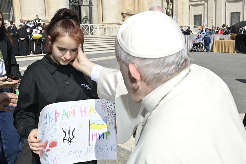 El papa Francisco saluda a una niña mientras se reúne con un grupo de ucranianos después de su audiencia general semanal en la Plaza de San Pedro en el Vaticano el 27 de abril de 2022. Ella era una de 11 huérfanos que escaparon de Ucrania y encontraron ayuda a principios de marzo de una organización católica italiana. (Foto CNS/Vatican Media)