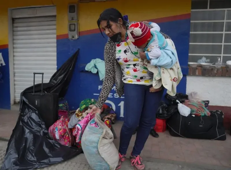 La migrante venezolana Luisiana Córdoba organiza sus pertenencias mientras se toma un descanso en Gachancipa, Colombia, el 28 de junio de 2020. Córdoba llevaba una semana en la carretera e intentaba llegar a Venezuela con sus tres hijos, tras perder su trabajo en Ecuador. (Foto Manuel Rueda/CNS)