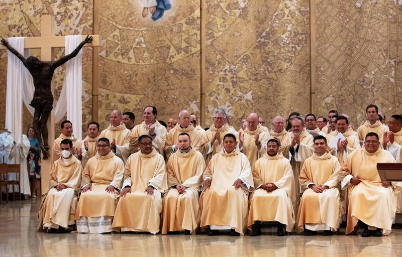 De izquierda a derecha: Los recién ordenados sacerdotes Daniel Vega, Daniel López, Justin Ordoveza, Kamil Ziolkowski, Ramón Reyes, Juan Gutiérrez, Juan Martínez y Guillermo "Memo" Alonso son ovacionados en la misa de ordenación del 4 de junio de 2022. (Víctor Alemán)