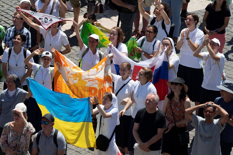 Unas monjas sostienen una bandera ucraniana mientras el Papa Francisco dirige el Ángelus desde la ventana de su estudio con vistas a la Plaza de San Pedro en el Vaticano el 31 de julio de 2022. (Foto CNS /Vatican Media vía Reuters)