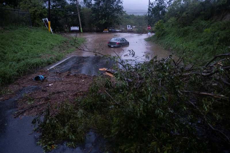 Un automóvil quedó detenido tras una inundación después de que el huracán Fiona afectó la zona de Yauco, Puerto Rico, el 18 de septiembre de 2022. Toda la isla estaba sin electricidad. (Foto CNS/Ricardo Arduengo, Reuters)