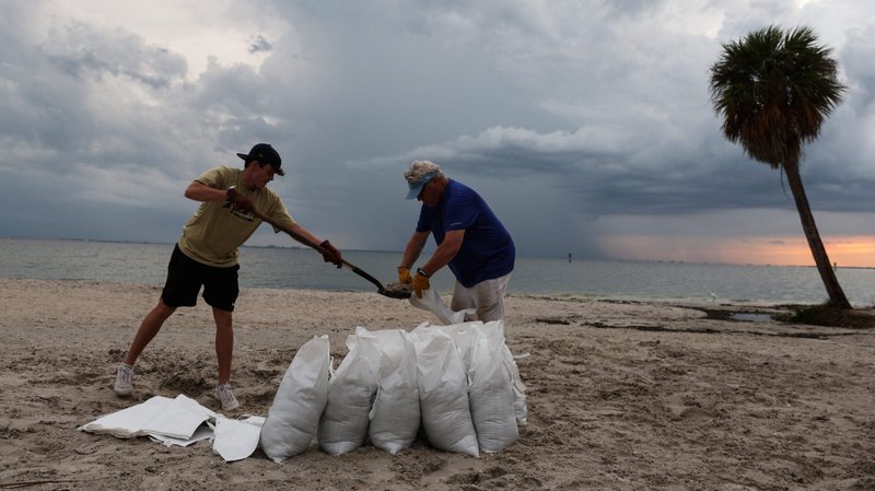 Rich Reynolds y su hijo, John, llenan sacos de arena en Tampa, Florida, el 26 de septiembre de 2022, mientras el huracán Ian giraba hacia el estado. (Foto CNS /Shannon Stapleton, Reuters)