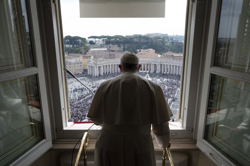 Jóvenes de Portugal se acercan al papa Francisco en la ventana de su estudio con vista a la Plaza de San Pedro el 23 de octubre de 2022, mientras lo ayudan a usar una tableta para ser el primero en registrarse para asistir a la Jornada Mundial de la Juventud 2023 en Lisboa. (Foto CNS/Vatican Media)