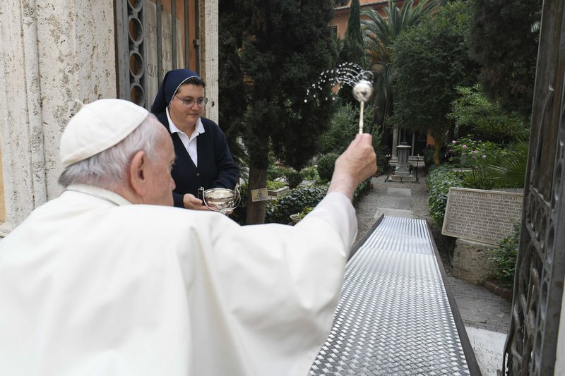 El Papa Francisco utiliza agua bendita para bendecir las tumbas de los enterrados en el Cementerio Teutónico del Vaticano, un cementerio medieval ahora reservado principalmente para los sacerdotes de habla alemana y los miembros de las órdenes religiosas, durante una visita el 2 de noviembre de 2022, la fiesta de Todos los Santos. (Foto CNS /Vatican Media)