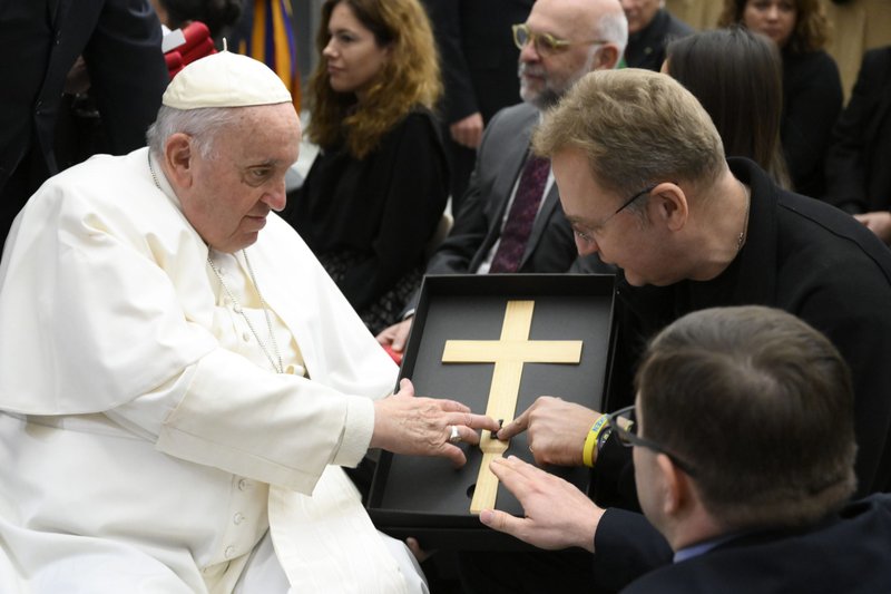 Pope Francis touches a piece of shrapnel removed from a child injured in the Russian-Ukrainian war. The shrapnel was presented by Andriy Sadovy, the mayor of Lviv, Ukraine, at the pope's general audience in the Paul VI hall at the Vatican Dec. 7, 2022. (CNS photo/Vatican Media)