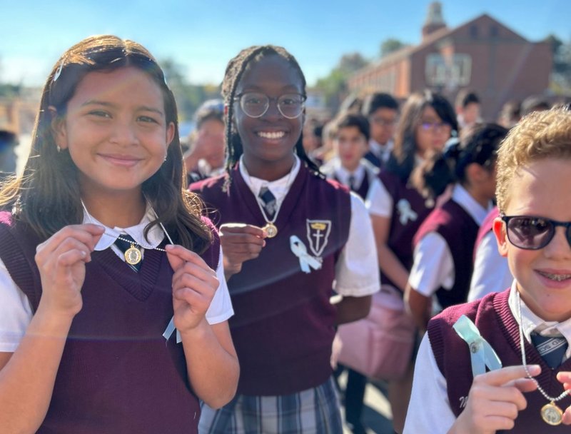 De izquierda a derecha: Los estudiantes de sexto grado Indeliza Nuño, Chidera Ogueli y Mason Worley de la Escuela Católica San Bernardo en Bellflower con sus Medallas Milagrosas recién bendecidas el 8 de diciembre de 2022. (Foto enviada)