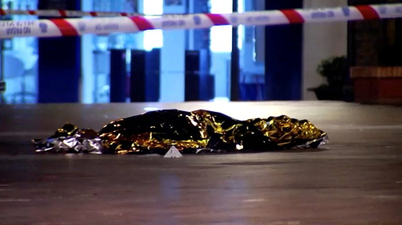 Un cuerpo cubierto con una manta térmica es visto en el lugar de un incidente de apuñalamiento fuera de la Iglesia de Santa María Auxiliadora en Algeciras, España, 25 de enero 2023, en esta captura de pantalla de un video. Según la agencia española de noticias EFE, el atacante, identificado como Yasin Kanza, entró en la iglesia por primera vez en la tarde del 25 de enero y atacó con un machete al padre salesiano Antonio Rodríguez, de 74 años, mientras celebraba la misa. El sacerdote sobrevivió al ataque. A continuación, Kanza se dirigió a la iglesia de Nuestra Señora de La Palma, donde atacó a Diego Valencia, sacristán de la parroquia. Aunque la víctima huyó, Kanza le persiguió e hirió mortalmente a Valencia. Su cuerpo fue encontrado en la Plaza Alta, frente a la iglesia. (Foto OSV News/FORTA vía Reuters)