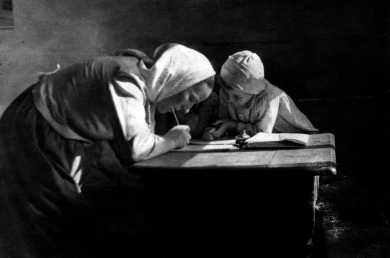 Wiktoria Ulma aparece escribiendo en una mesa con su hija mayor, Stasia. Józef y Wiktoria Ulma dieron refugio en secreto a ocho judíos durante casi dos años en la Polonia ocupada por los alemanes, escondiéndolos del régimen asesino nazi durante la Segunda Guerra Mundial. Los Ulma están en vías de beatificación, ya que el Vaticano los declarará mártires el 17 de diciembre de 2022. Los nazis mataron a la familia y a los judíos que albergaban la madrugada del 24 de marzo de 1944, justo antes de Pascua. (OSV NEWS photo/courtesy Polish Institute of National Remembrance)