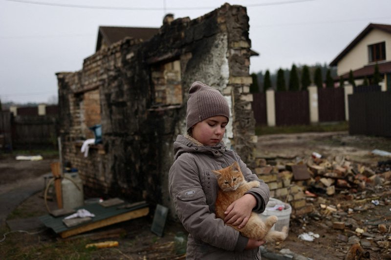 Yuliya Zaika, una niña ucraniana, juega con su gato en el pueblo de Moschuner Kyiv, Ucrania, el 8 de noviembre de 2022. (Foto CNS/Murad Sezer, Reuters)