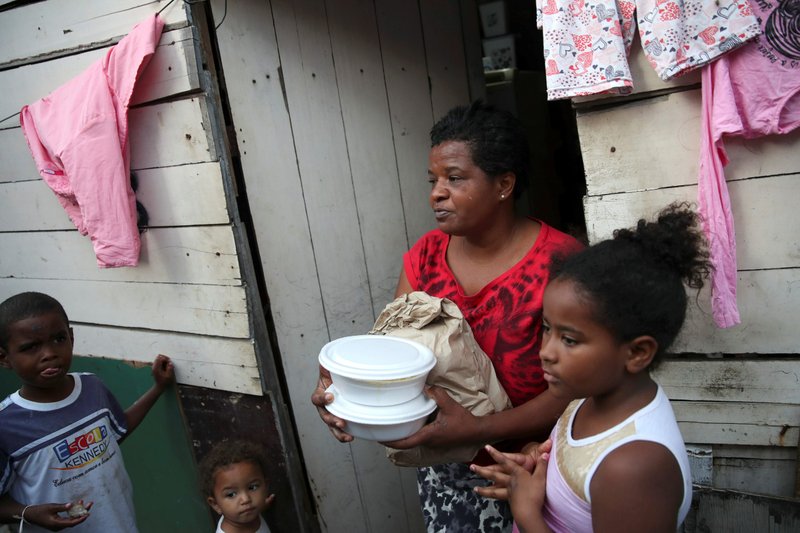 Habitantes de un barrio pobre de Río de Janeiro reciben comida y pan de los miembros del Instituto doAcao el 24 de junio de 2021. El creciente número de personas que se enfrentan a la inseguridad alimentaria en Brasil llevó a los obispos del país a centrarse en "Fraternidad y Hambre" durante su Campaña de Fraternidad 2023 esta Cuaresma. (OSV News /Ricardo Moraes, Reuters)