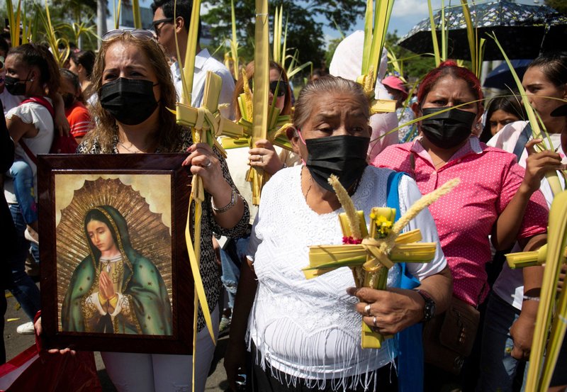 Mujeres llevan una imagen de María y hojas de palma para ser bendecidas con agua bendita antes de una procesión de Domingo de Ramos fuera de la catedral en Managua, Nicaragua, 2 de abril de 2023, después de que el gobierno nicaragüense prohibiera las procesiones públicas. (Foto OSV News/Maynor Valenzuela, Reuters)