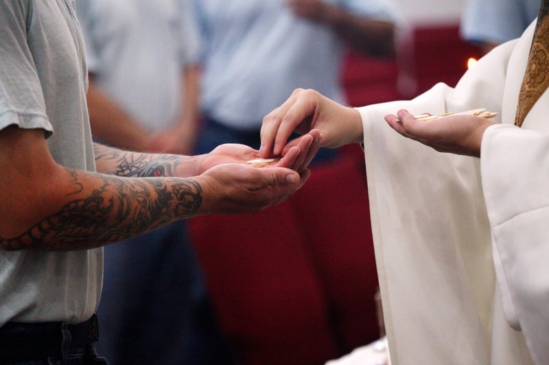 Una foto de archivo muestra a un preso recibiendo la Comunión en Ellsworth Correctional Facility de Ellsworth, Kansas. Los católicos implicados en la pastoral penitenciaria intentan llevar esperanza y la luz de Cristo a los que "cumplen condena". (Foto de OSV News/CNS file, Karen Bonar, The Register)