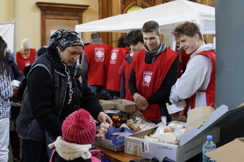 Voluntarios de Cáritas Hungría entregan alimentos y otra ayuda a personas en la estación de tren de Keleti en Budapest, Hungría, en esta foto de archivo del 12 de marzo de 2022. Los Caballeros de Malta y la Cruz Roja también participaron en los esfuerzos para distribuir alimentos, suministros, ropa y juguetes a los refugiados ucranianos, así como a las personas sin hogar y gitanos locales en Budapest. (Foto de CNS/Junno Arocho Esteves)