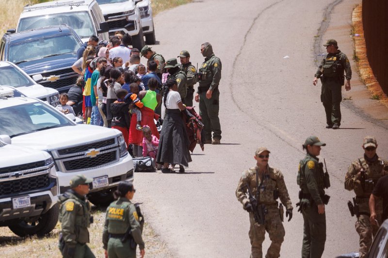 Agentes de la Patrulla Fronteriza de Estados Unidos organizan a un grupo de familias entre las vallas fronterizas primaria y secundaria cerca de San Diego el 9 de mayo de 2023. Un gran número de migrantes se reunieron en la frontera mientras Estados Unidos se preparaba para levantar las restricciones del Título 42 de la era COVID-19 que han bloqueado a los migrantes en la frontera entre Estados Unidos y México para solicitar asilo desde 2020. (Foto de OSV News/Mike Blake, Reuters)