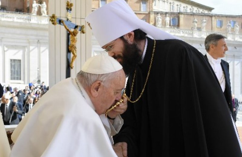 El papa Francisco besa el encolpion, un ícono que usan los obispos católicos ortodoxos y bizantinos en lugar de una cruz pectoral, mientras saluda al metropolita Antonio de Volokolamsk, director de relaciones externas de la Iglesia ortodoxa rusa, al final de la audiencia general del papa el 3 de mayo de 2023 , en la Plaza de San Pedro en el Vaticano. (Foto del CNS/Vatican Media)