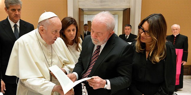 El Papa Francisco entrega al presidente brasileño Luiz Lula da Silva una copia firmada de su mensaje para el Día Mundial de la Paz mientras intercambian regalos en una sala de reuniones del salón de audiencias del Vaticano el 21 de junio de 2023. (CNS /Vatican Media)