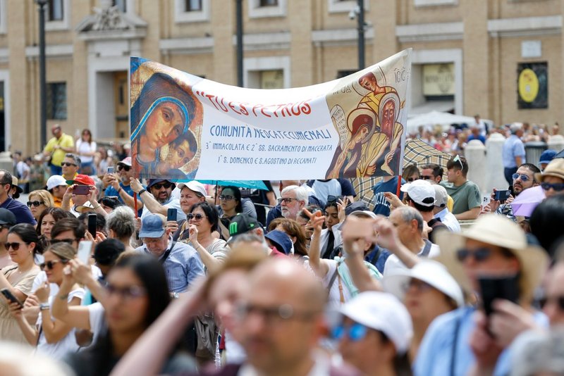 Miembros del Camino Neocatecumenal sostienen una pancarta mientras los visitantes se reúnen en la Plaza de San Pedro del Vaticano para rezar el Ángelus con el Papa Francisco el 4 de junio de 2023. (CNS /Lola Gomez)