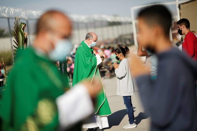 Sacerdotes distribuyen la Comunión durante una misa al aire libre en celebración de la Jornada Mundial del Migrante y el Refugiado en el albergue Casa del Migrante en Ciudad Juárez, México, 19 de septiembre de 2021. (OSV News /Jose Luis Gonzalez, Reuters)