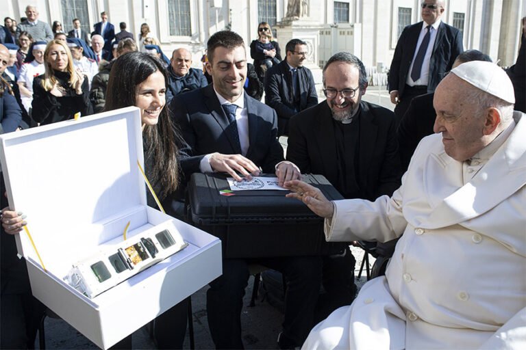 Durante su audiencia general en el Vaticano el 29 de marzo de 2023, el Papa Francisco bendice "Spei Satelles", un pequeño satélite CubeSat que fue lanzado al espacio el 12 de junio de 2023. El satélite transporta una versión "nano" de su libro "¿Por qué tienes miedo? ¿No tienes fe?". Está construido para enviar señales a la Tierra para que los radioaficionados puedan escuchar los mensajes de esperanza y paz del Papa. (CNS /cortesía de Vatican Media)