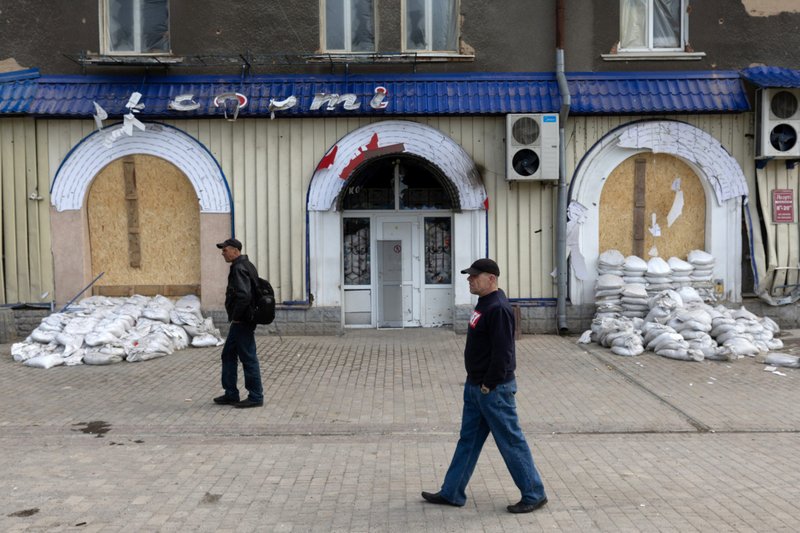 Dos hombres caminan frente a un restaurante en Slovyansk, Ucrania, el 23 de abril de 2022, que fue atacado con una bomba de racimo en medio de la invasión rusa de Ucrania. En una entrevista concedida a la CNN el 9 de julio de 2023, el presidente de Estados Unidos, Joe Biden, defendió lo que calificó de "decisión muy difícil" de proporcionar municiones de racimo a Ucrania en medio de la invasión rusa de ese país, armas a las que se opone el Vaticano. (OSV News /Jorge Silva, Reuters)