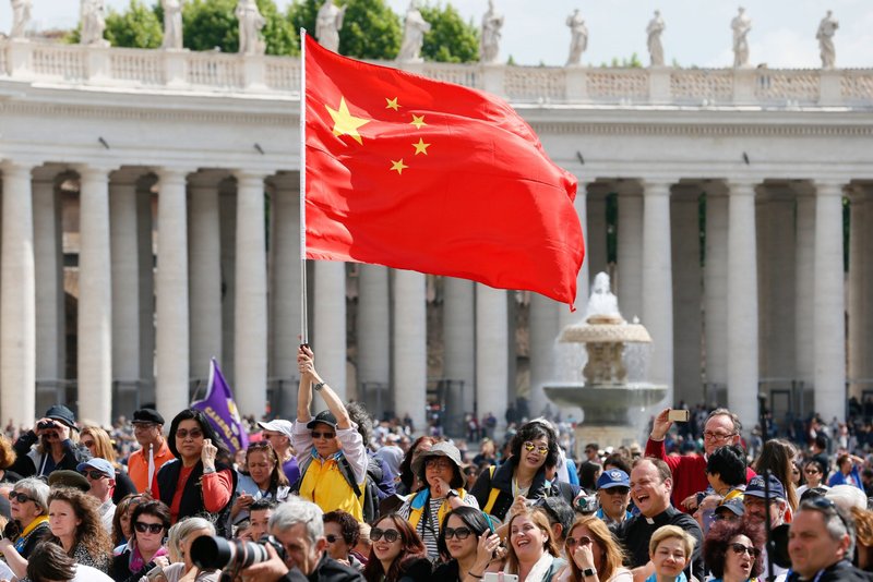 En esta foto de archivo, un visitante ondea la bandera de China mientras que el Papa Francisco lidera la audiencia general en la Plaza de San Pedro en el Vaticano, el 22 de mayo, 2019. (Foto CNS/Paul Haring)