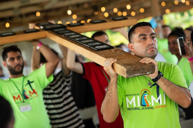 Gustavo Mejía, director de jóvenes de la Parroquia de San José en Miami Beach, ayuda a llevar la Cruz de la Jornada Mundial de la Juventud del Sur de la Florida durante la Misa del 6 de agosto de 2023, concluyendo una serie de eventos paralelos de la Jornada Mundial de la Juventud del 1 al 6 de agosto, reflejando los eventos que tuvieron lugar en Lisboa, Portugal, para aquellos que no pudieron viajar allá. El arzobispo de Miami, Thomas G. Wenski, celebró la Misa de clausura en el centro de retiros Land of the Pierced Hearts en Homestead, Florida. (Foto OSV News/Tom Tracy)