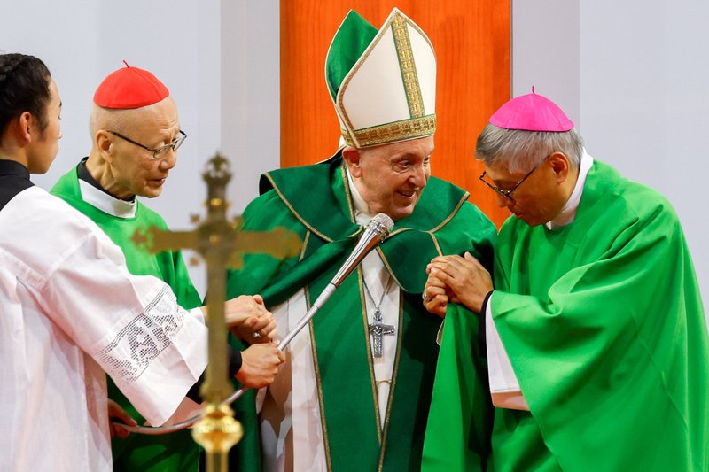 El Papa Francisco agarra las manos del cardenal retirado John Tong Hon de Hong Kong, izquierda, y del cardenal designado Stephen Chow Sau-yan de Hong Kong, derecha, mientras los presenta a los asistentes a su Misa en el Steppe Arena en Ulán Bator, Mongolia, el 3 de septiembre de 2023. (Foto de CNS/Lola Gomez)