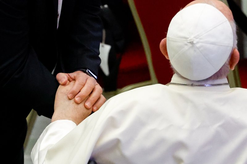 Un participante en el Sínodo se agarra de la mano del Papa Francisco a su llegada al Aula de Audiencias Pablo VI del Vaticano para una sesión de trabajo de la asamblea del Sínodo de los Obispos el 6 de octubre de 2023. (CNS /Lola Gomez)