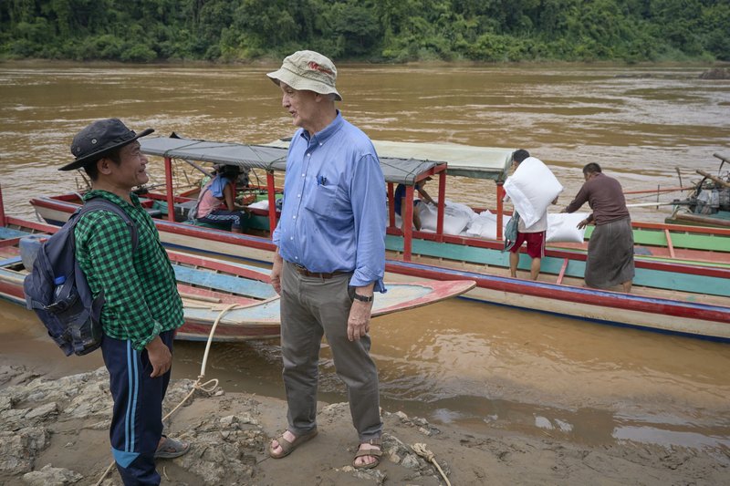 El padre Maryknoll John Barth, misionero estadounidense, habla con Pah Kler, catequista católico birmano, mientras se carga arroz en barcos en Mae Sam Laep, un pueblo tailandés a orillas del río Salween, el 29 de septiembre de 2022. Kler estaba supervisando el traslado de alimentos y otros suministros humanitarios a las familias desplazadas que se esconden en los bosques de Myanmar. (OSV News /CNS file, Paul Jeffrey)
