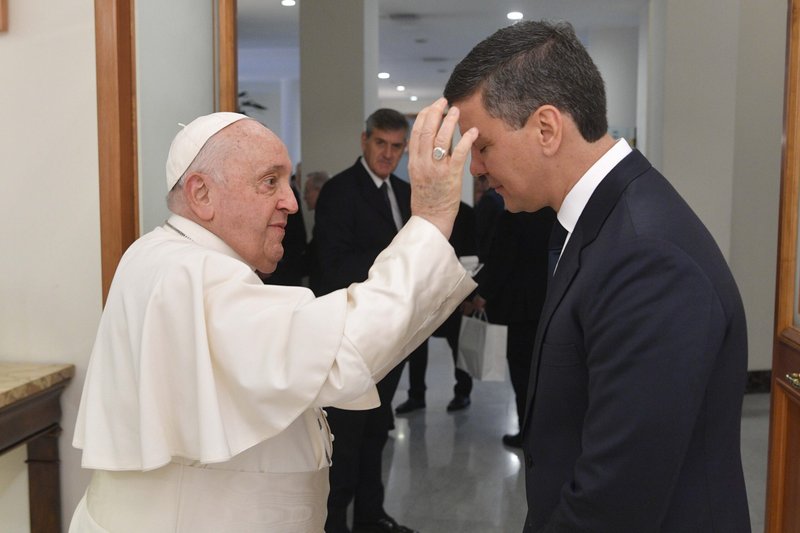 El Papa Francisco, que se recupera de una inflamación pulmonar, bendice al presidente de Paraguay, Santiago Peña Palacios, al término de su encuentro en la Domus Sanctae Marthae del Vaticano el 27 de noviembre de 2023. La foto indica que la cánula que el Papa tenía en su mano derecha el día anterior para antibióticos intravenosos había sido retirada. (Foto CNS/Vatican Media)
