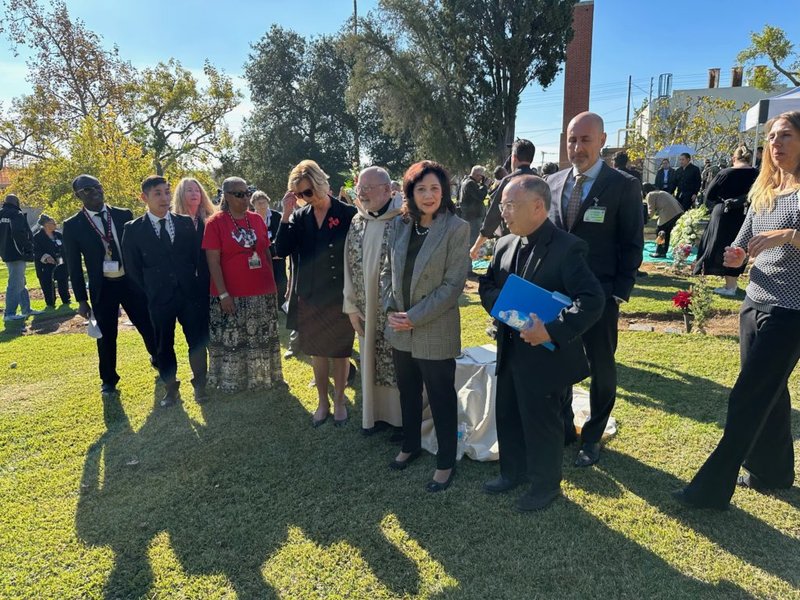 El Obispo Auxiliar de LA Brian Nunes, derecha, habla durante una ceremonia de entierro interreligiosa en el Cementerio Evergreen el 14 de diciembre. (Foto enviada)