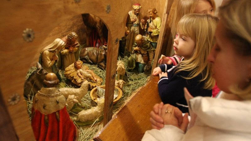 Una familia reza delante de un belén tras la Divina Liturgia de la fiesta de la Natividad en la Iglesia Católica Ucraniana de la Sagrada Familia en Lindenhurst, Nueva York (CNS /Gregory A. Shemitz)