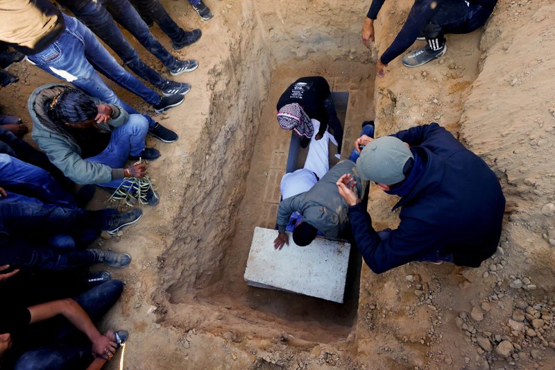 El cuerpo de Samer Fouad al-Talalka, miembro de la minoría árabe beduina de Israel tomado como rehén por Hamás y muerto por error por el ejército israelí, es depositado en la tumba durante su funeral en el pueblo de Hura, en el sur de Israel, el 16 de diciembre de 2023. Al-Talalka fue uno de los tres rehenes de Hamás asesinados por error por tropas de las FDI en Gaza el 15 de diciembre. (Foto de OSV News/Clodagh Kilcoyne, Reuters)