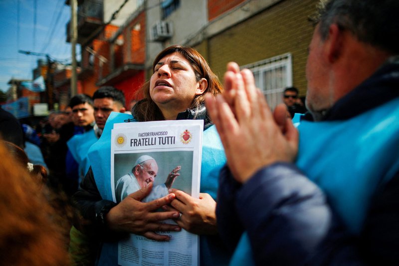 Una mujer reza mientras sostiene un periódico con una imagen del Papa Francisco durante una misa celebrada el 5 de septiembre de 2023 en Buenos Aires para rechazar los ataques verbales contra el pontífice por parte del candidato presidencial Javier Milei, de la coalición La Libertad Avanza. (OSV News photo/Agustin Marcarian, Reuters)