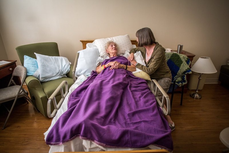 Una mujer sentada junto a la cama de su madre en 2016 en el hospicio de Greeff en St. Louis. (OSV News/CNS file, Lisa Johnston, St. Louis Review)
