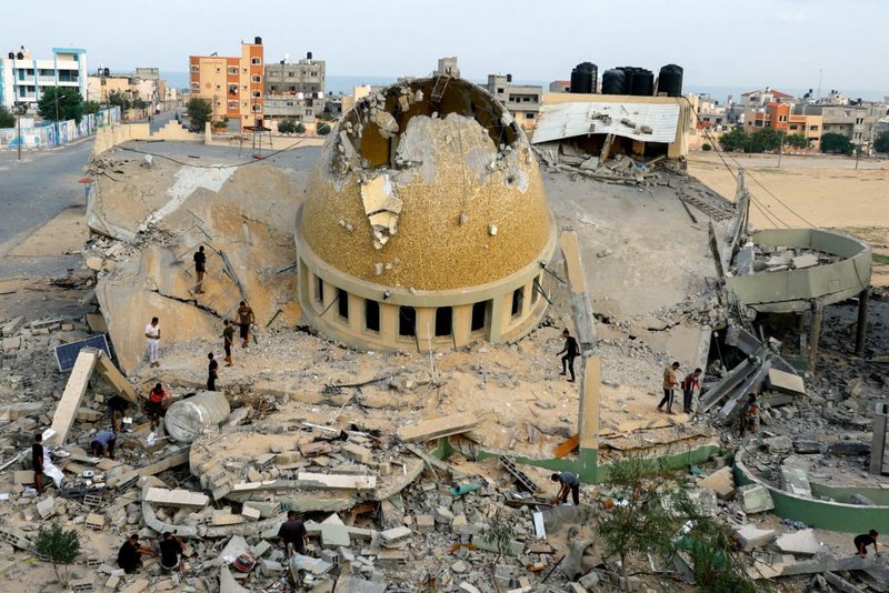 Palestinos inspeccionan una mezquita destruida por ataques israelíes en Khan Younis, en el sur de la Franja de Gaza, 8 de octubre de 2023, un día después de un brutal ataque contra Israel por más de 1.300 terroristas de Hamás que dejó más de 1.200 israelíes y otros nacionales muertos. Hamás tomó como rehenes a más de 200 personas, entre ellas unos 30 niños, y los llevó de vuelta a Gaza. Más de 30.000 palestinos de Gaza han muerto desde el comienzo de la guerra entre Israel y Hamás, según el Ministerio de Sanidad de Gaza. (OSV Noticias/Ibraheem Abu Mustafa, Reuters)