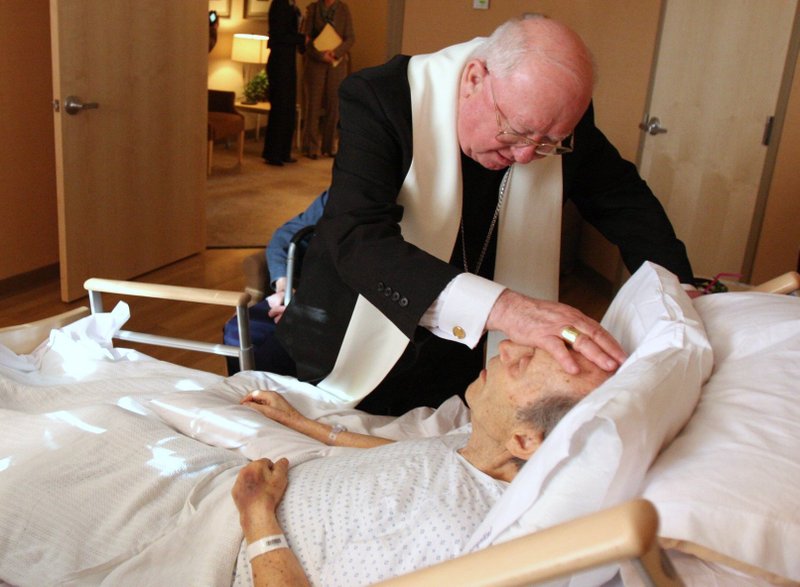 El obispo William F. Murphy de Rockville Centre, N.Y., ya jubilado, aparece en una foto de archivo bendiciendo a un paciente del Good Shepherd Hospice Inpatient Center de Port Jefferson, N.Y. (OSV News /CNS file, Gregory A. Shemitz, Long Island Catholic)