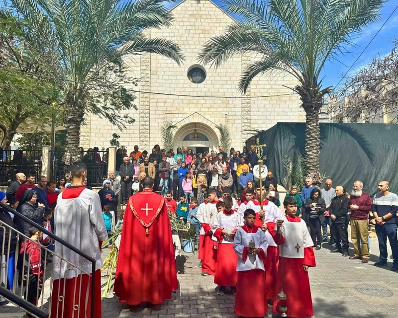 Monaguillos procesionan en el exterior de la iglesia de la Sagrada Familia de la ciudad de Gaza durante la misa del Domingo de Ramos, 25 de marzo de 2024. Más de 500 cristianos se refugian en la parroquia en medio de la actual guerra entre Hamás e Israel. (Foto de OSV News/Cortesía del Patriarcado Latino de Jerusalén)