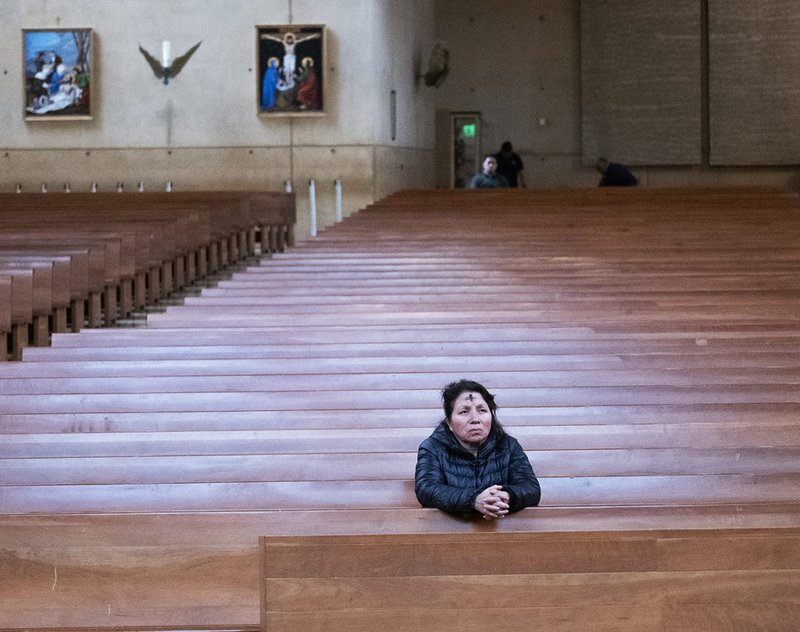 Una mujer reza en la Catedral de Nuestra Señora de los Ángeles, casi vacía, tras la Misa del Miércoles de Ceniza, el 14 de febrero. (Víctor Alemán)