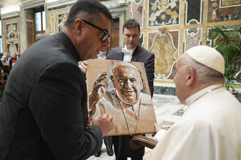 El Papa Francisco recibe un cuadro suyo al final de una audiencia con personas relacionadas con la fundación Santa Ángela Merici de Siracusa, Italia, en el Palacio Apostólico del Vaticano el 6 de abril de 2024. (CNS /Vatican Media)