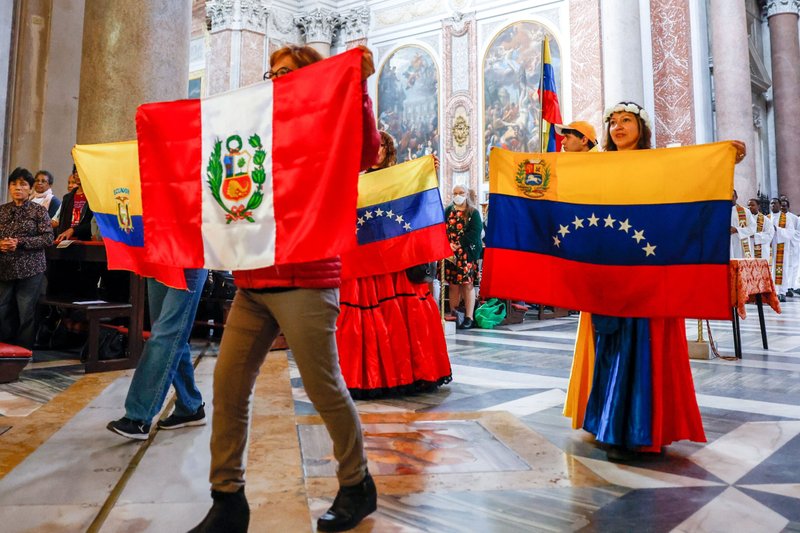 Personas de Perú, Ecuador y Venezuela portan las banderas de sus países en la Basílica de Santa María de los Ángeles y de los Mártires de Roma al comienzo de la Misa del 21 de mayo de 2023. La Misa formaba parte del Festival de los Pueblos de la Diócesis de Roma, una celebración anual que pone de relieve la diversidad cultural, étnica y lingüística de los católicos de la ciudad. (Foto CNS/Lola Gómez)