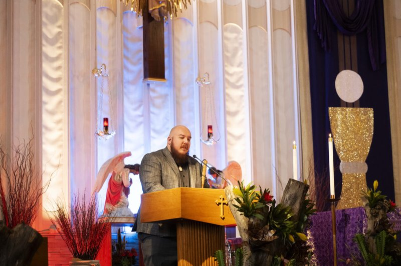 Ryan Rohrich, quien perdió la vista después de ser diagnosticado con un raro tumor canceroso, recita una lectura usando braille durante una misa reciente en la Iglesia de San Juan de Dios en Norwalk. (Victor Alemán)