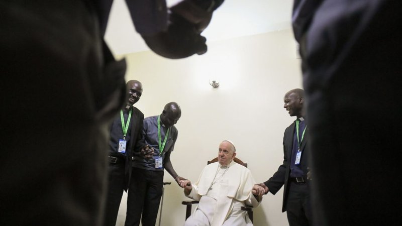 El Papa Francisco se da la mano y reza con una docena de jesuitas que trabajan en Sudán del Sur durante una reunión el 4 de febrero de 2023, en Juba. (CNS /Vatican Media)