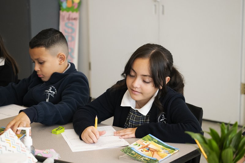 Los estudiantes de la Escuela Católica San Miguel, Xaribel G. y Andrés R., realizan actividades en clase después de leer como parte de un nuevo programa diseñado para ayudar a los niños a mejorar en lectura y matemáticas. (Victor Alemán)