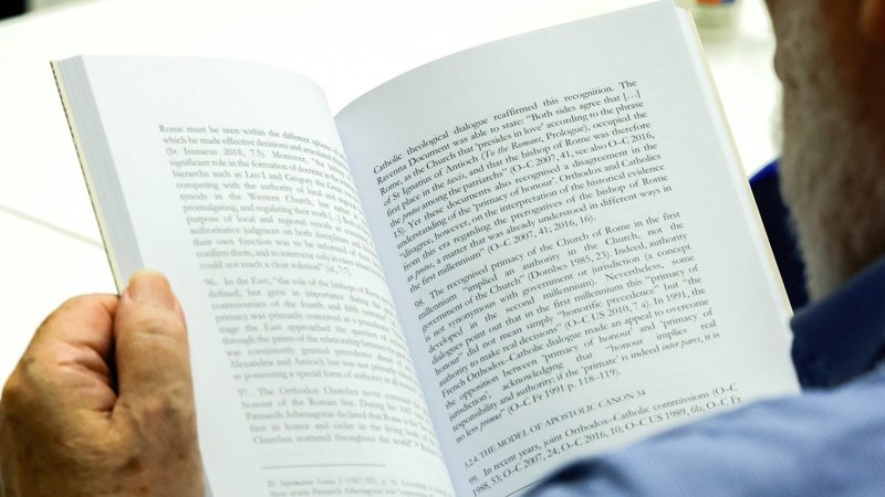 Un periodista echa un vistazo al documento de estudio titulado "El Obispo de Roma. Primacía y sinodalidad en los diálogos ecuménicos y en las respuestas a la encíclica 'Ut unum Sint'", durante su presentación a la prensa en el Vaticano el 13 de junio de 2024. (CNS photo/Lola Gomez)
