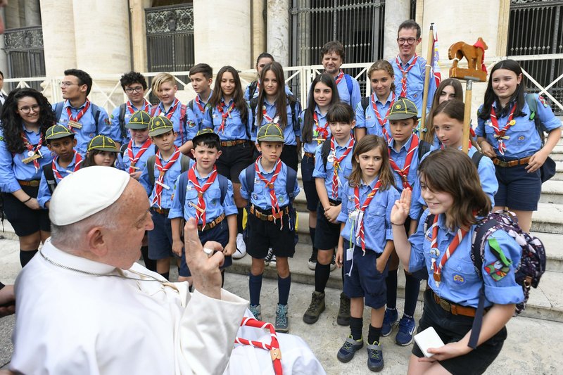 El Papa Francisco hace el signo y saludo scout con un grupo de scouts en la Plaza de San Pedro del Vaticano durante su audiencia general semanal el 19 de junio de 2024. (Foto CNS/Vaticano)